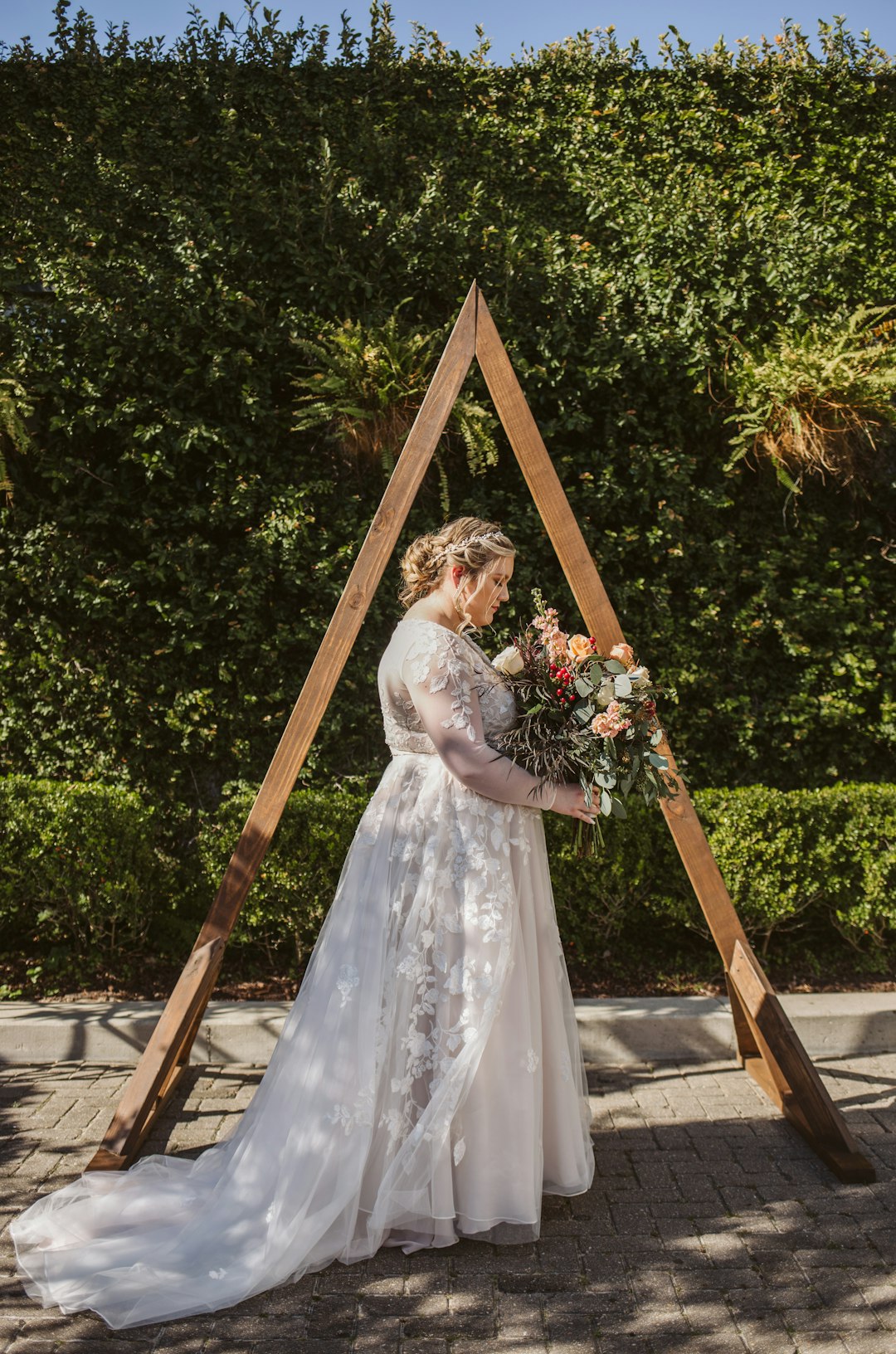 woman in white floral wedding dress holding bouquet of flowers