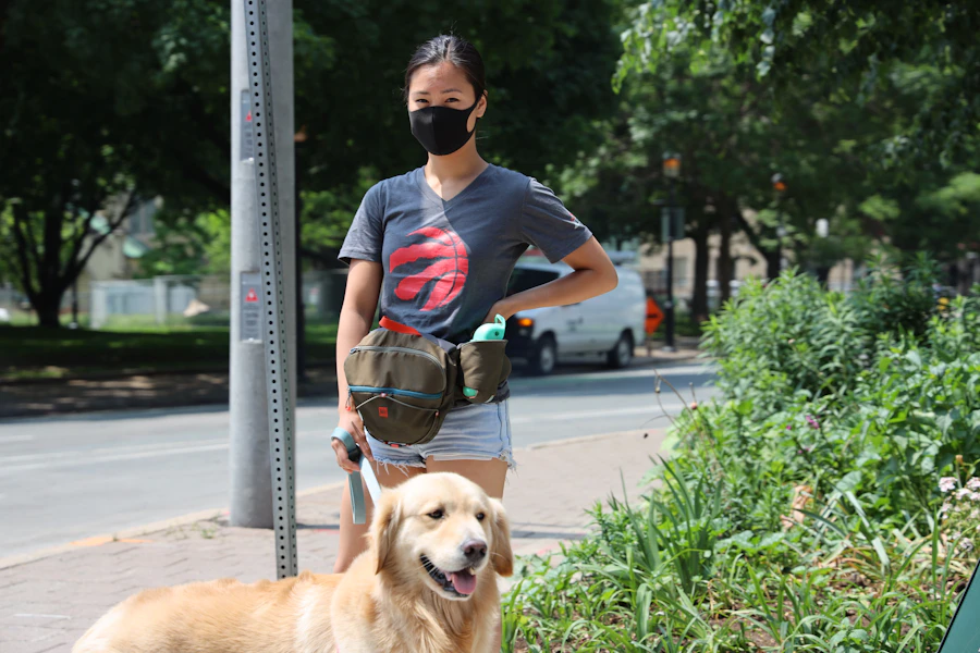 A man sitting outdoors beside an attentive golden retriever resting calmly at his side