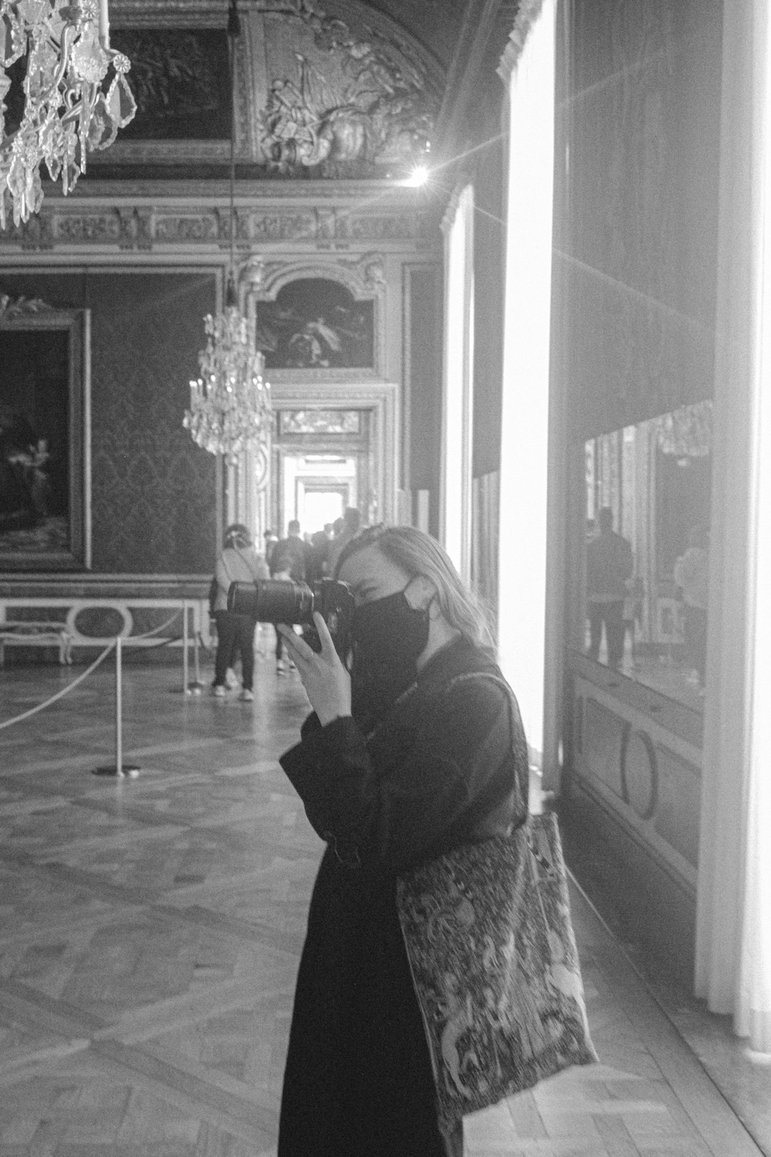 woman in black and white long sleeve shirt taking photo of a mirror