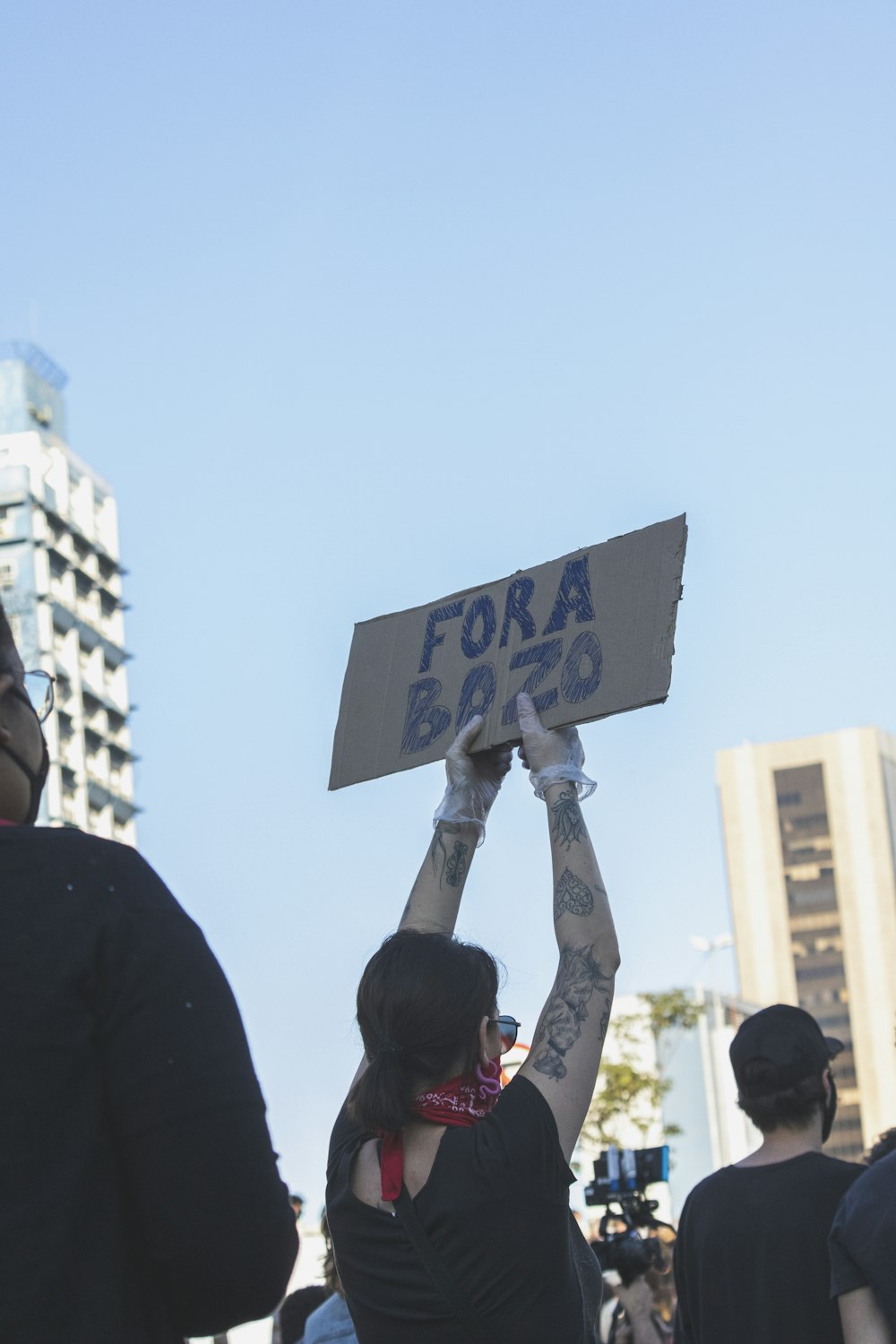 man in black shirt holding blue and white signage during daytime