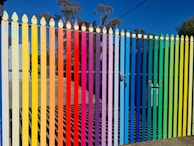 A vibrant blue fence freshly painted under bright sunlight, highlighting neat edges and even coverage.