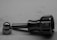 A metal component with a threaded bolt and a knurled grip lies next to a shiny, reflective cap or nut on a flat surface.