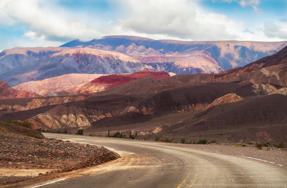 Montañas marrones y blancas bajo nubes blancas y cielo azul durante el día