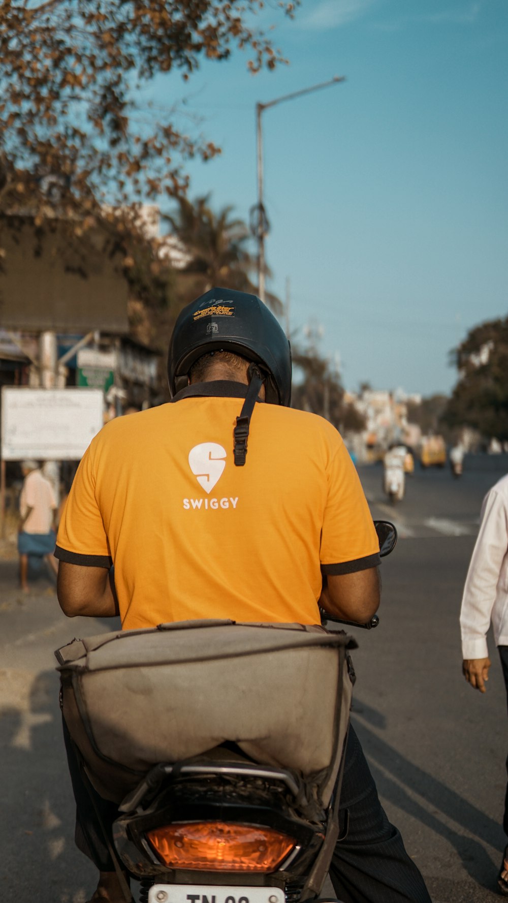 man in orange crew neck t-shirt wearing black helmet