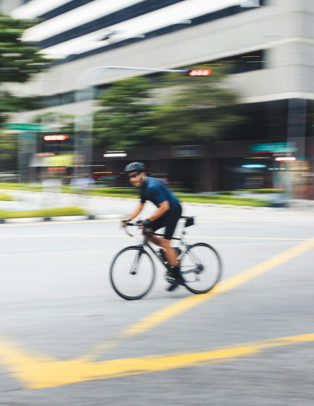 man in blue shirt riding on bicycle on road during daytime
