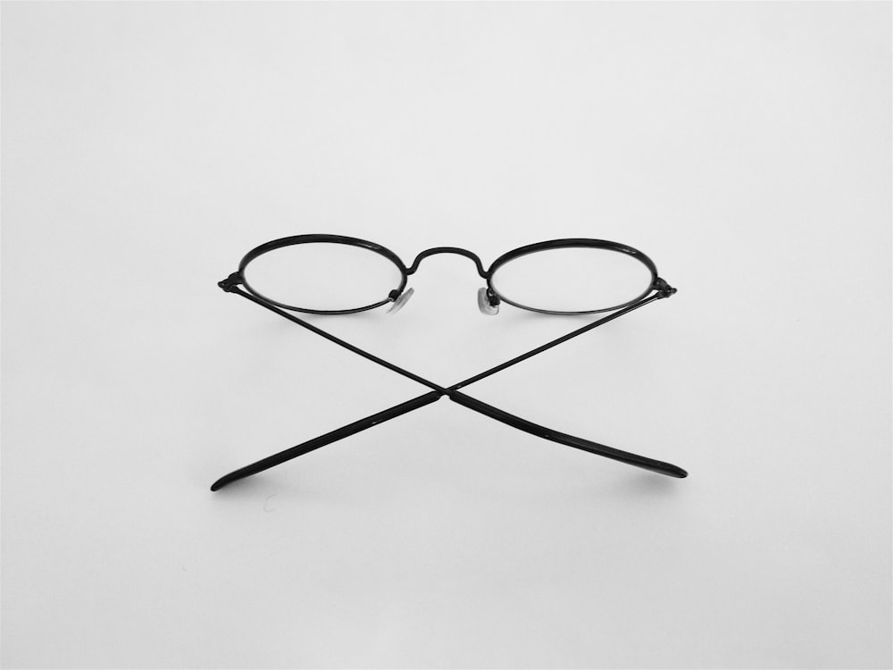black framed eyeglasses on white surface