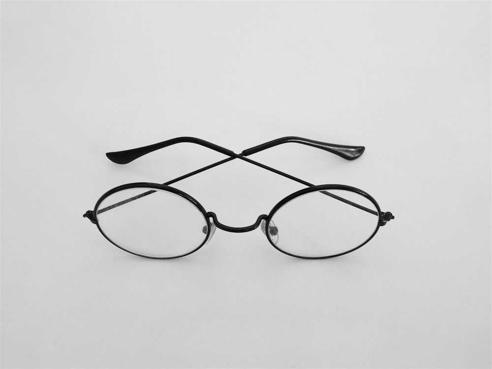 schwarz gerahmte Brille auf weißer Oberfläche