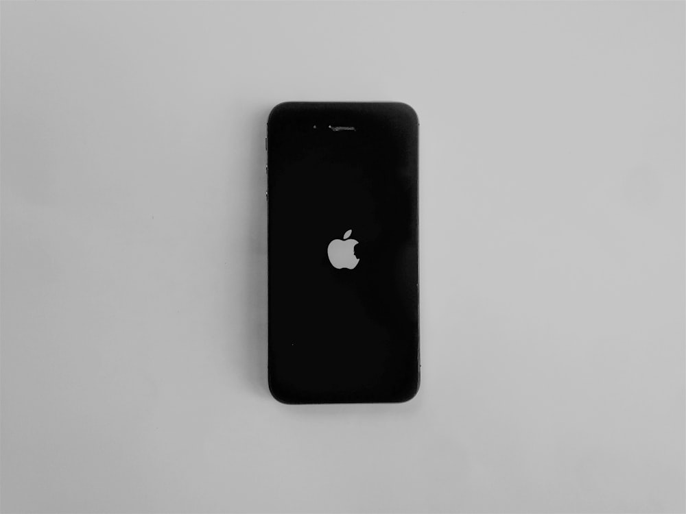 iPhone 4 negro sobre mesa blanca