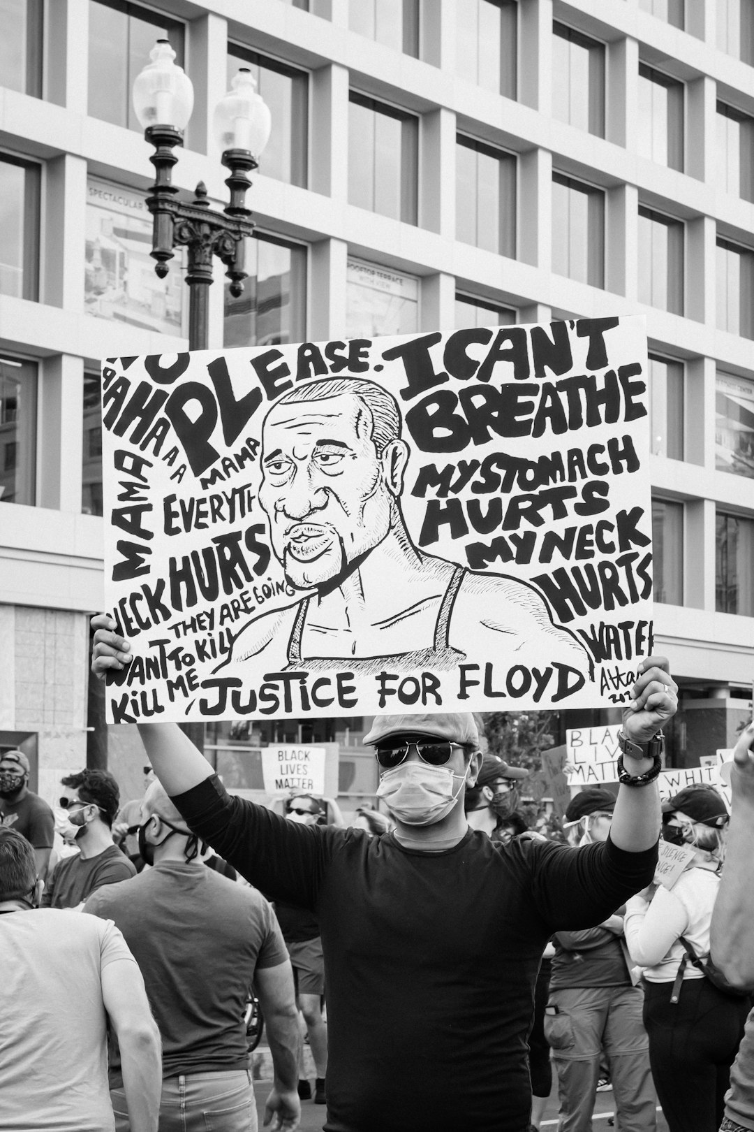 grayscale photo of man holding happy birthday signage