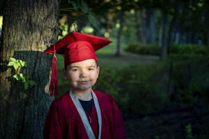 boy in blue academic dress and red academic hat