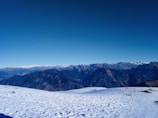 A panoramic view of the snowy Andes mountains under a clear blue sky