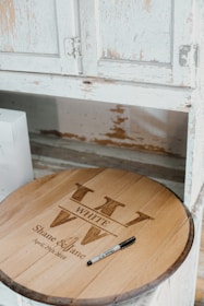 Elegant wooden guestbook cover engraved with names and date in a warm, natural setting.