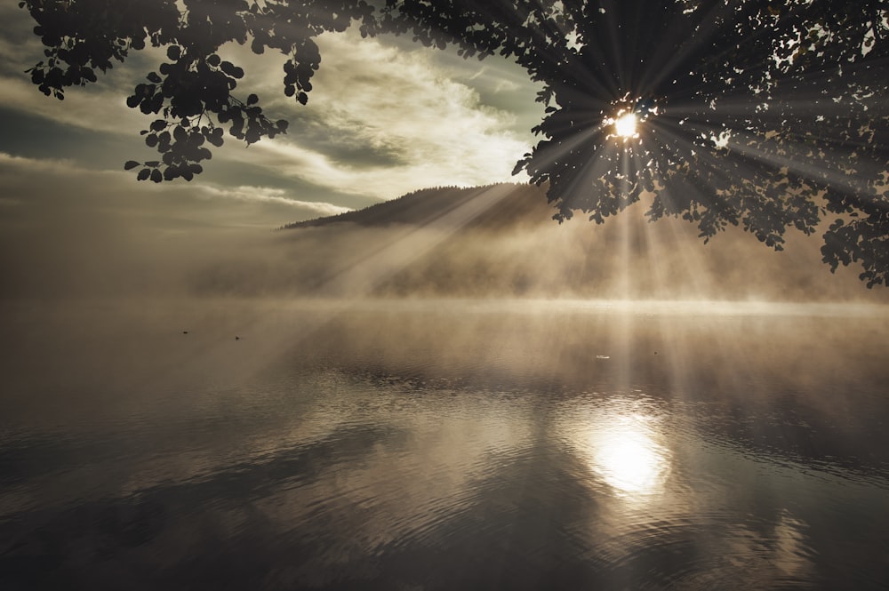 sun setting over the mountains and lake