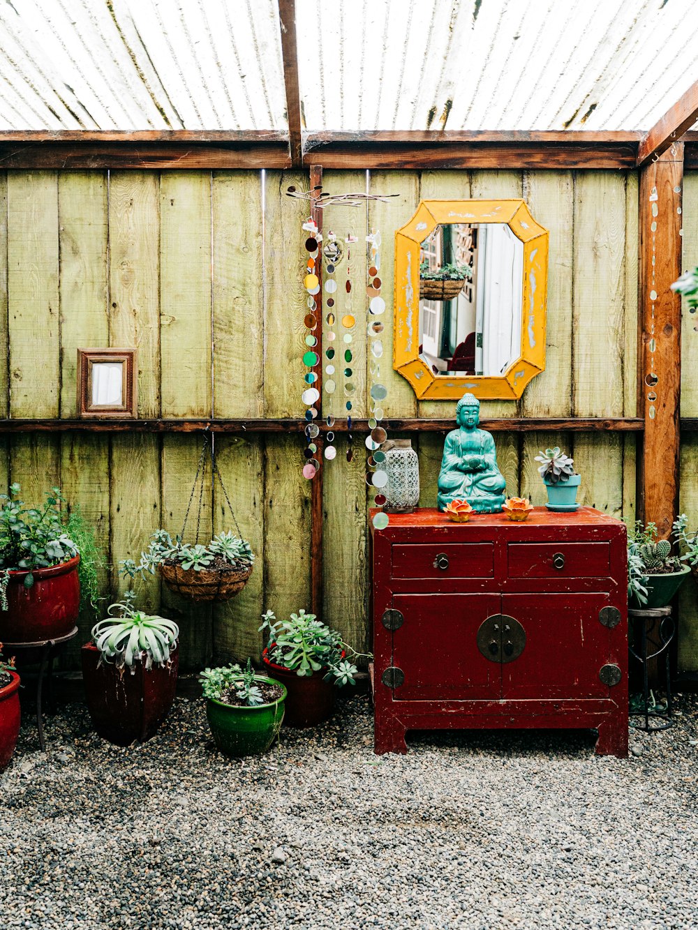 red wooden cabinet with green plants on top