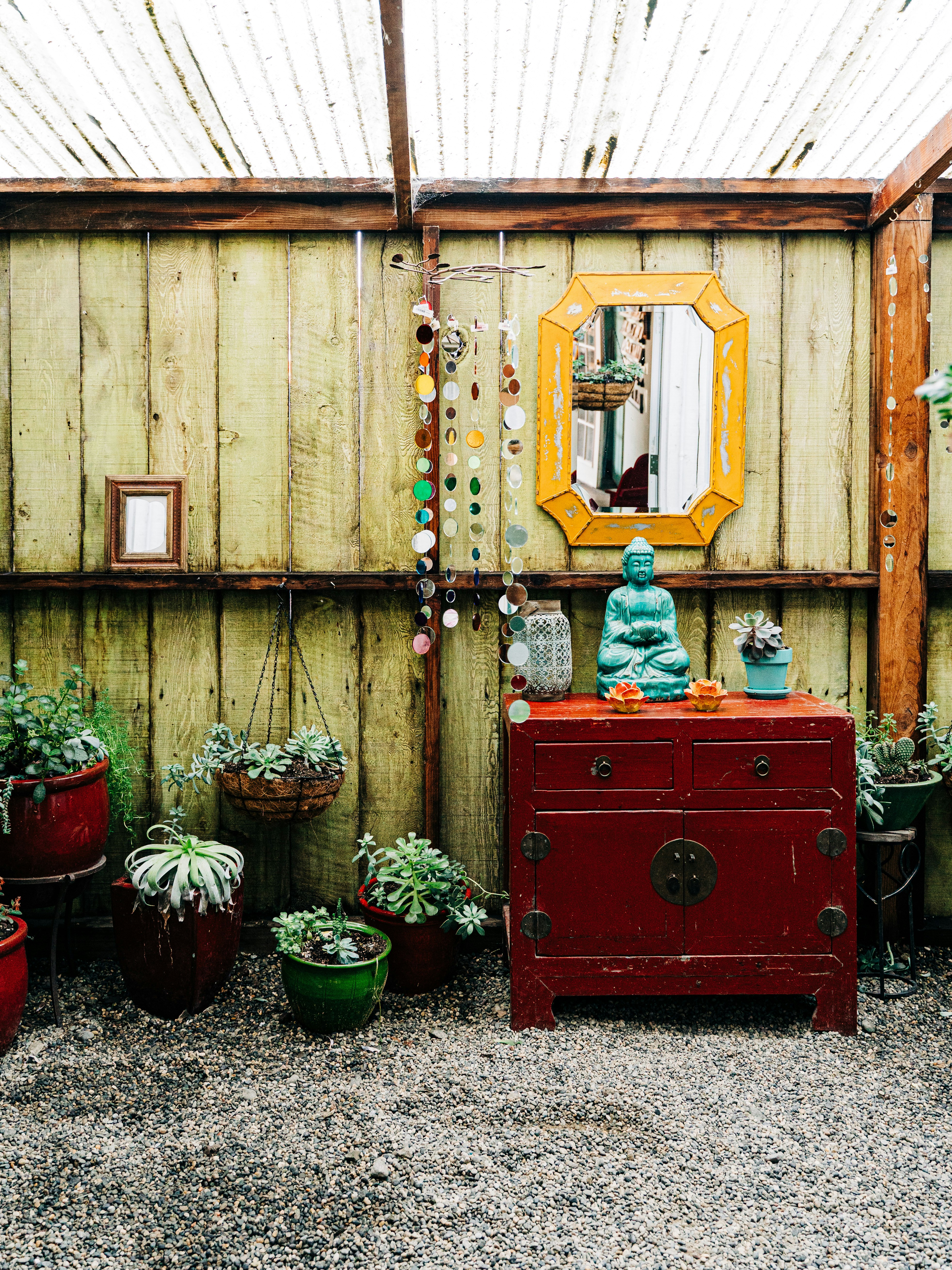 red wooden cabinet with green plants on top