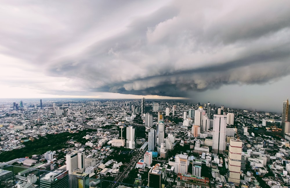 city with high rise buildings under white clouds during daytime