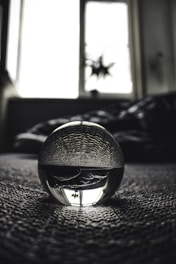 Close-up of a crystal ball glowing softly in a dimly lit room.