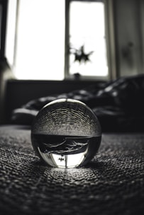 Close-up of a crystal ball glowing softly in a dimly lit room.