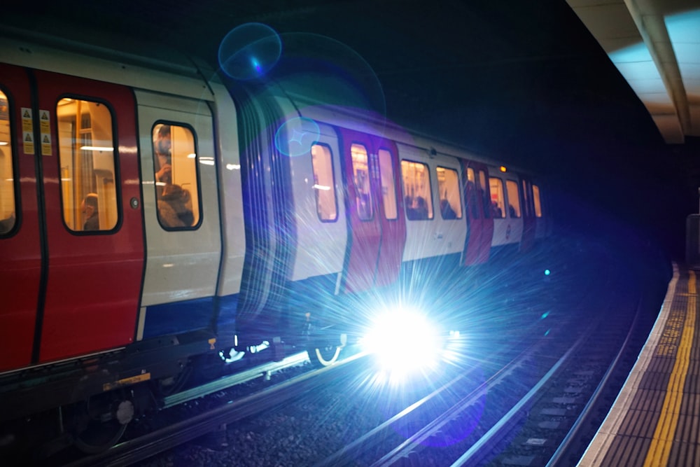 Tren morado y blanco en la vía férrea durante la noche