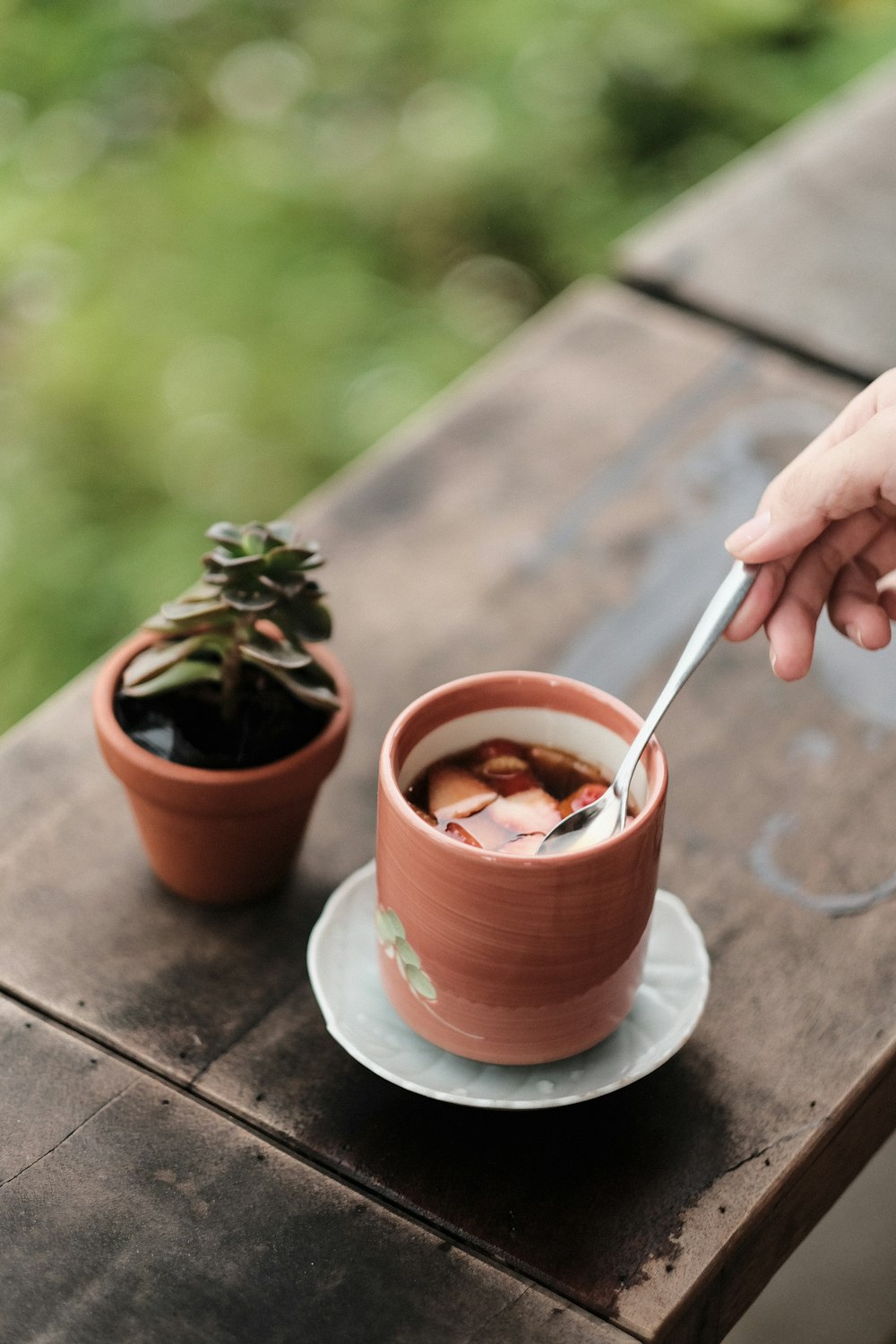 person holding silver spoon on brown ceramic bowl