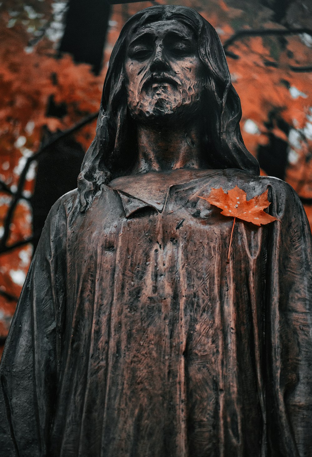 black statue of man holding orange flower