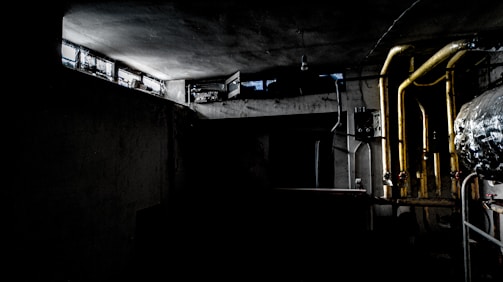 A dimly lit steampunk villain's lair with brass gears and glowing tubes.