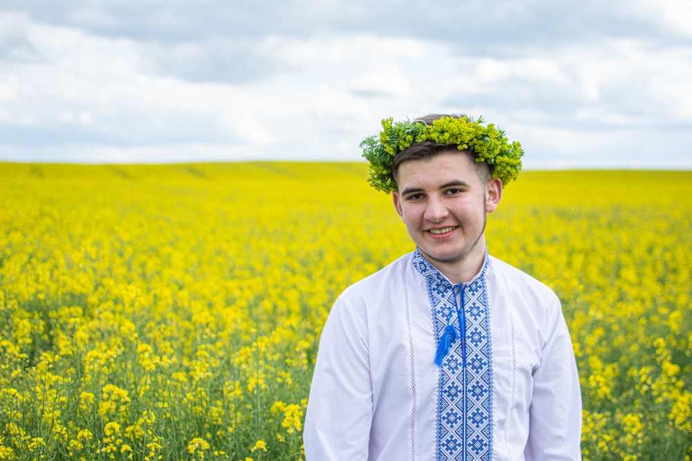 man in white dress shirt standing on yellow flower field during daytime