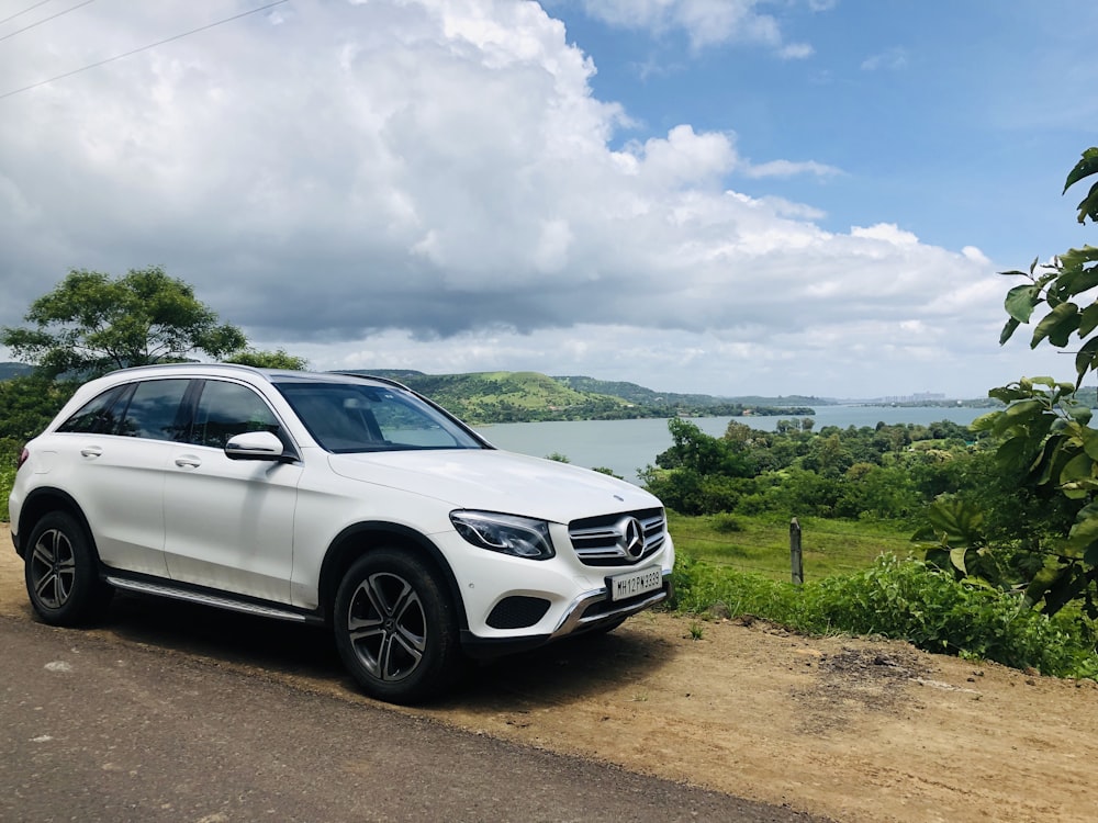 Sedán Mercedes Benz plateado en camino de tierra marrón durante el día