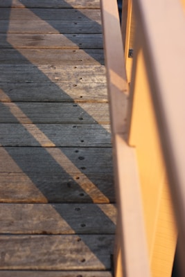 Wooden planks laid out on a construction site with sunlight filtering through.