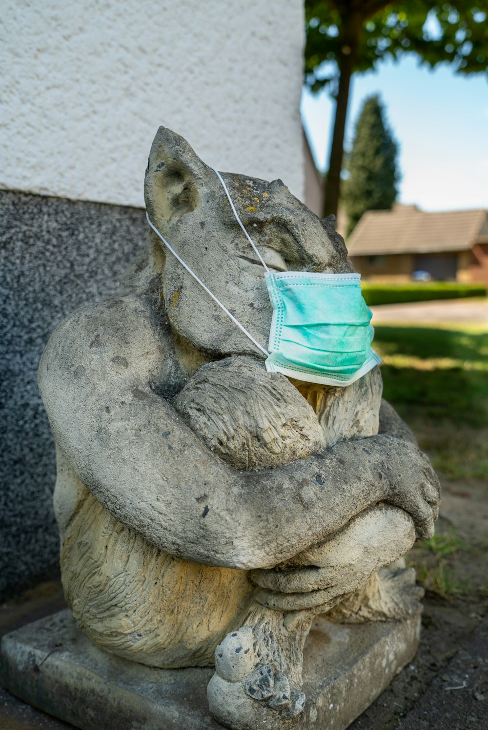 gray concrete statue with green and white bucket hat