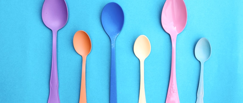 pink plastic spoon on pink and white polka dot textile