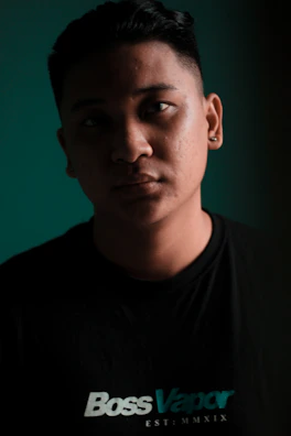 Model wearing a black t-shirt with a bold 'Agent Vibe' design under moody lighting.