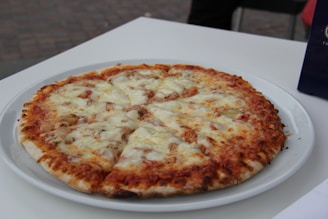 Close-up of a freshly baked pizza topped with golden chicken pieces and melted cheese.