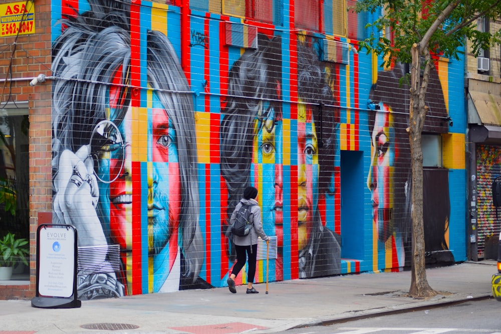 woman in black jacket walking on sidewalk during daytime