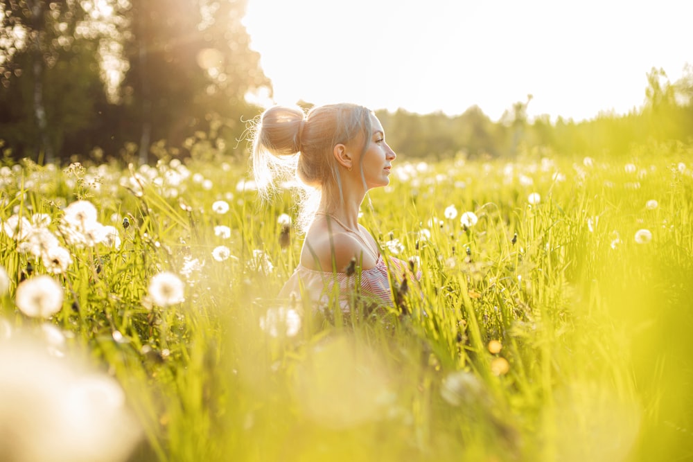 woman in black brassiere on green grass field during daytime