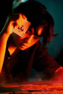 A dimly lit scene with a magnifying glass highlighting a game card, emphasizing the investigative theme.