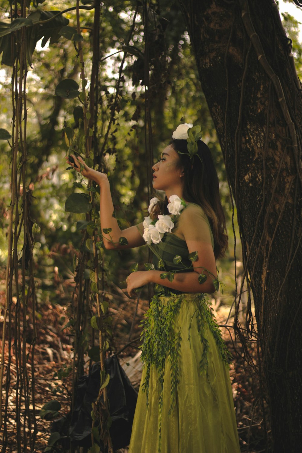 woman in yellow dress standing in the middle of forest during daytime