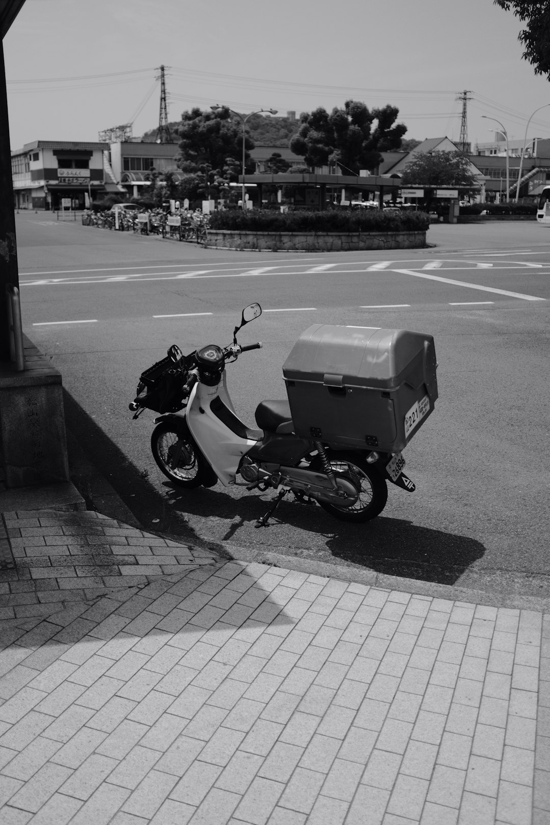 grayscale photo of motorcycle parked on sidewalk