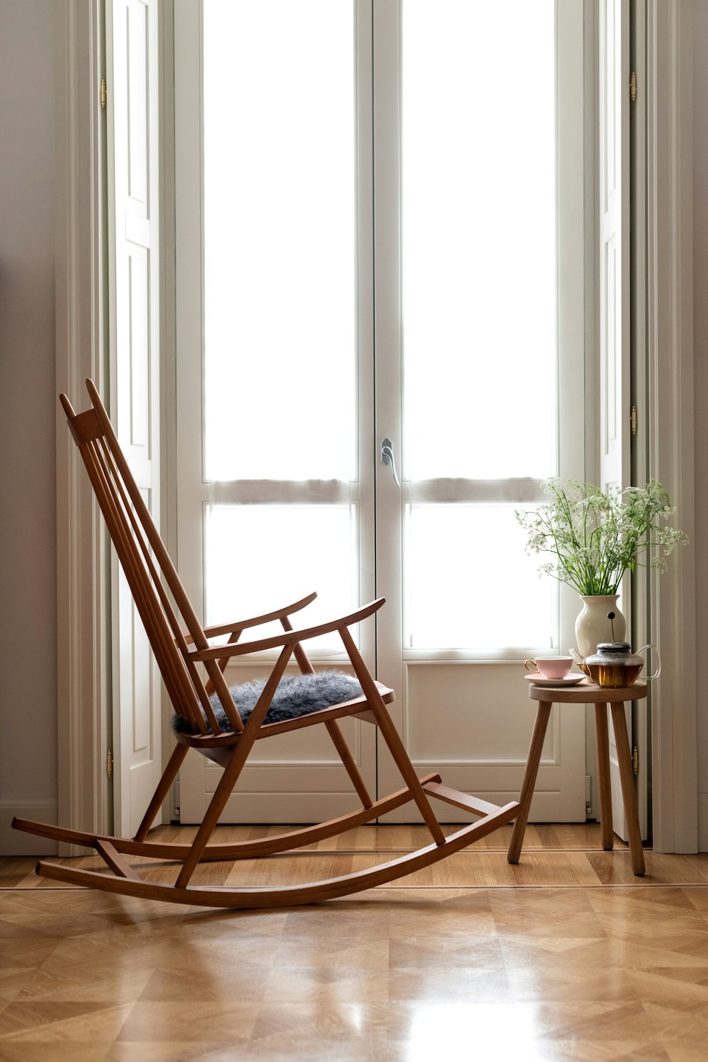 brown wooden rocking chair near window