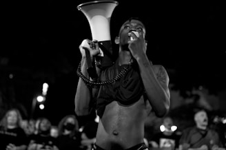 A determined citizen holding a megaphone in front of the Álvaro Obregón municipal building at dusk.