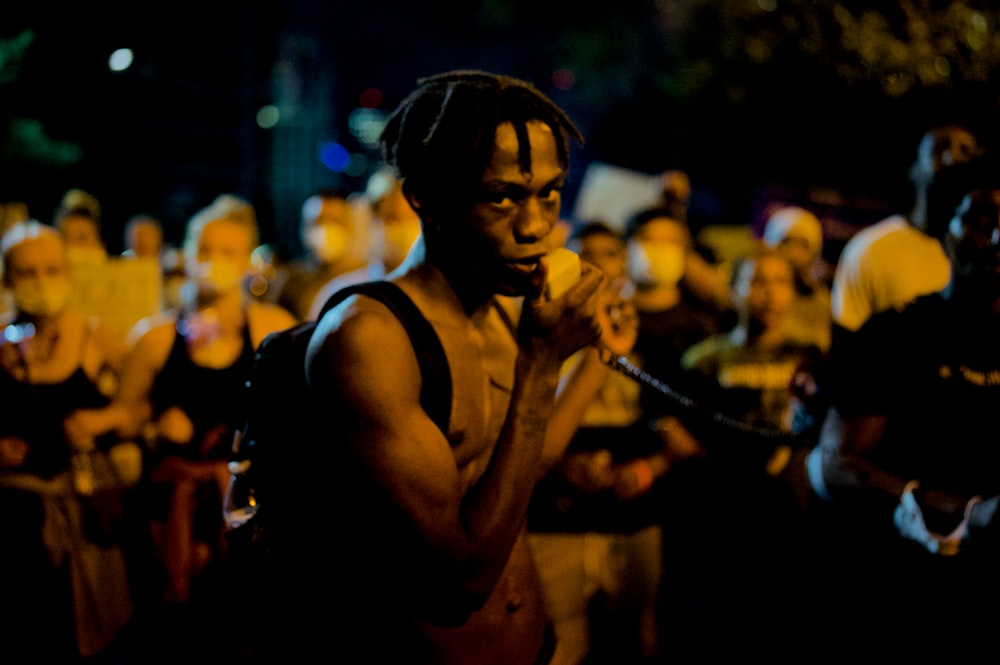 man in black tank top holding black string lights