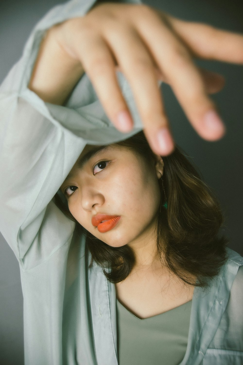 woman in white shirt covering her face with white textile