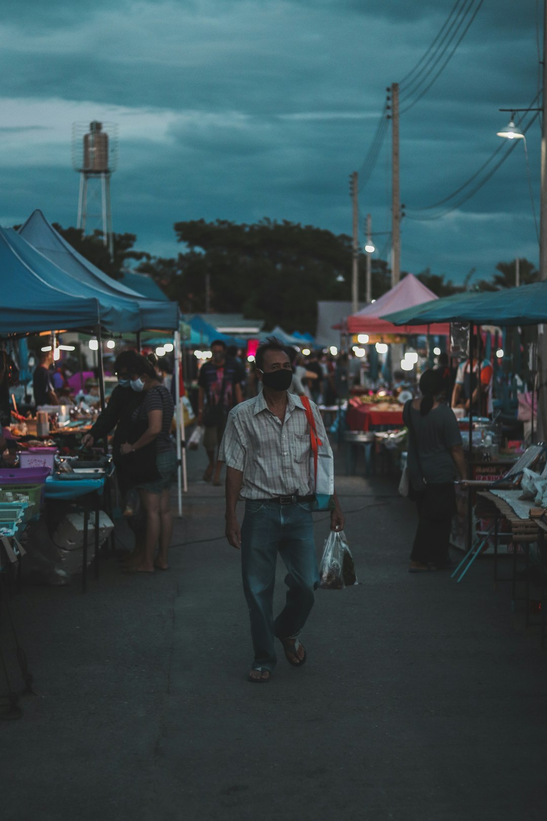 man in white and red plaid button up shirt walking on street during night time