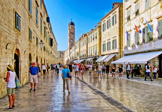 people walking on street near beige concrete building during daytime in Muralles de Dubrovnik Croatia