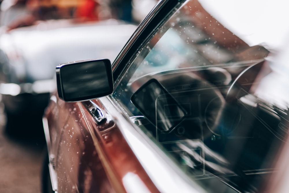 black car side mirror with water droplets