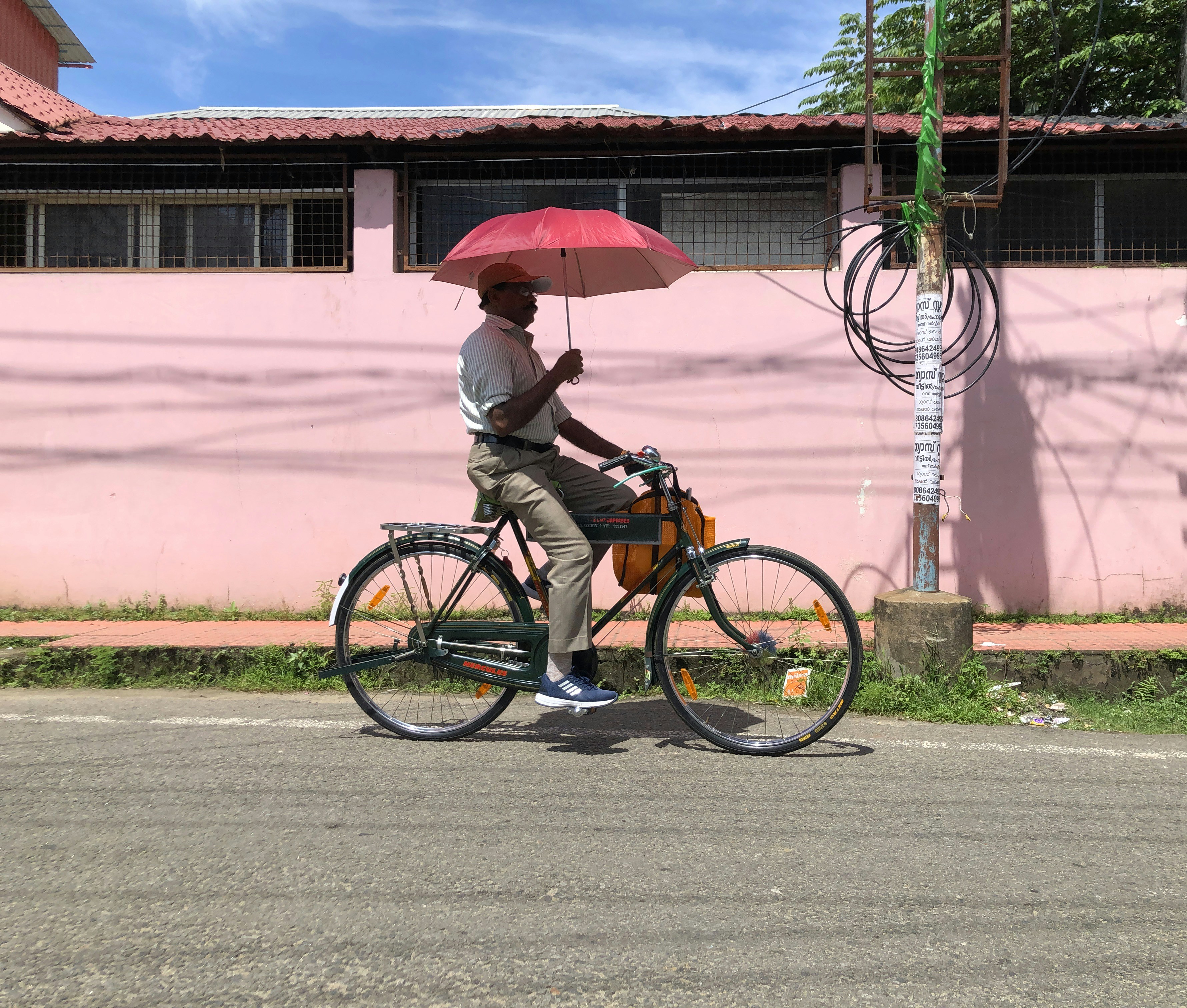 person in brown jacket and blue denim jeans riding on black bicycle during daytime