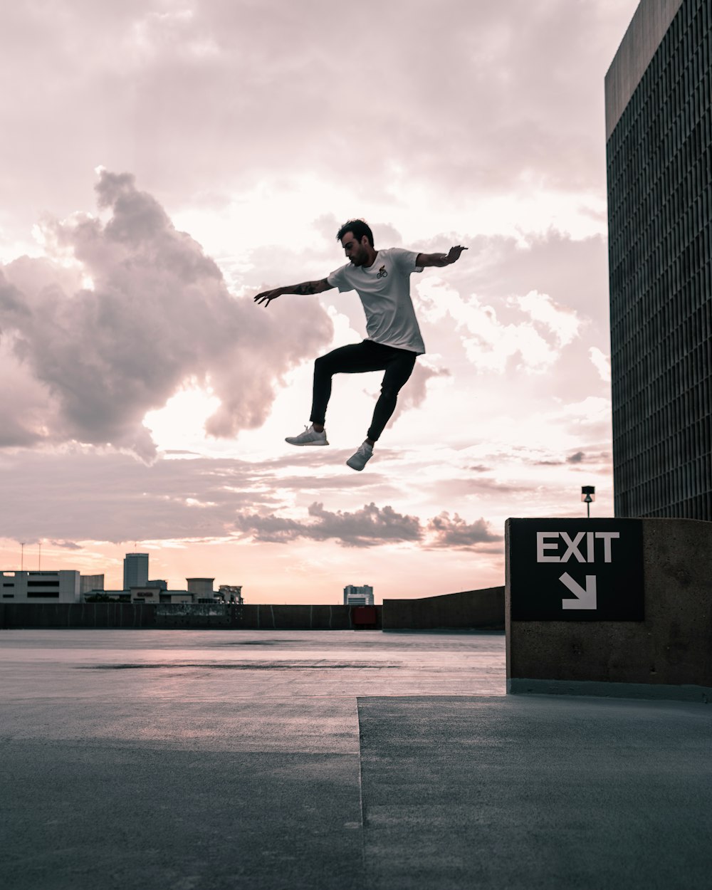 man in white shirt and black pants jumping on mid air