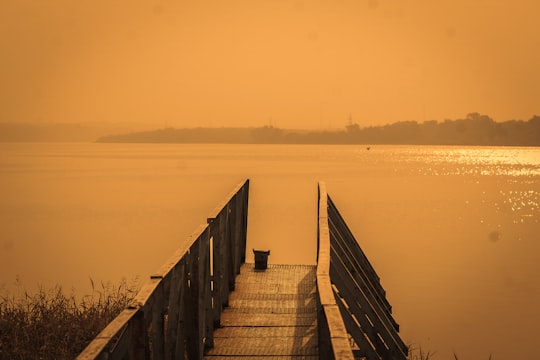 brown wooden dock on body of water during daytime in Kota India