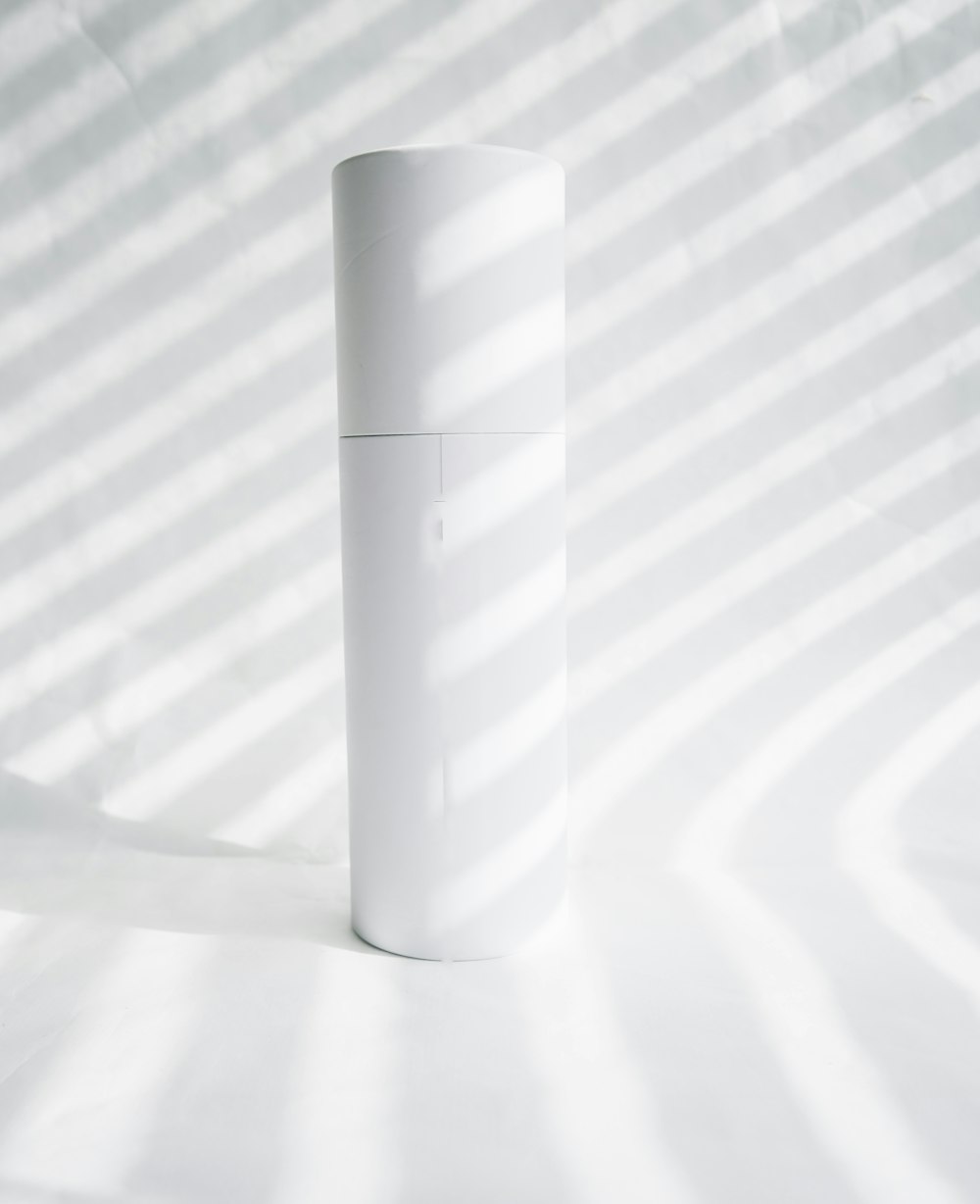 white plastic bottle on white table