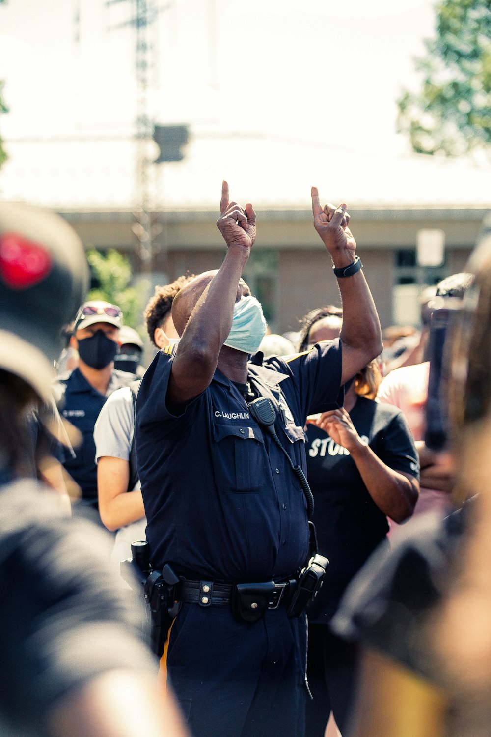 man in blue police uniform raising his hands